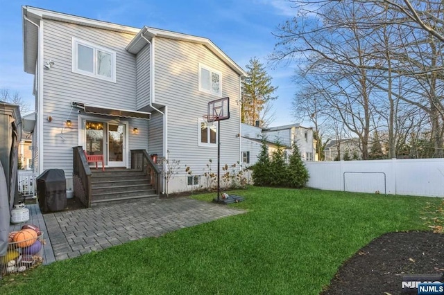 back of property with a lawn and a patio area