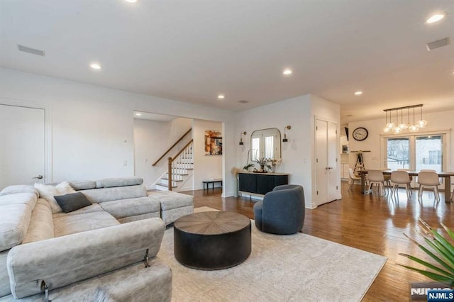 living room with hardwood / wood-style flooring and an inviting chandelier