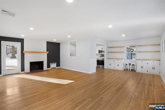 unfurnished living room featuring a fireplace and light wood-type flooring