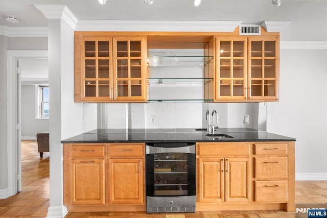 bar with sink, light parquet floors, wine cooler, ornamental molding, and dark stone counters