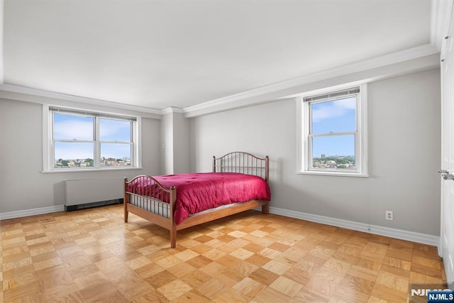 bedroom with multiple windows, crown molding, radiator, and light parquet floors