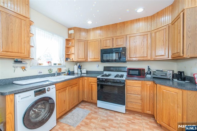 kitchen featuring sink, washer / dryer, range with gas cooktop, and light tile patterned flooring