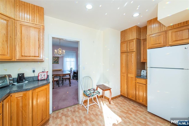 kitchen with a chandelier, hanging light fixtures, and white fridge