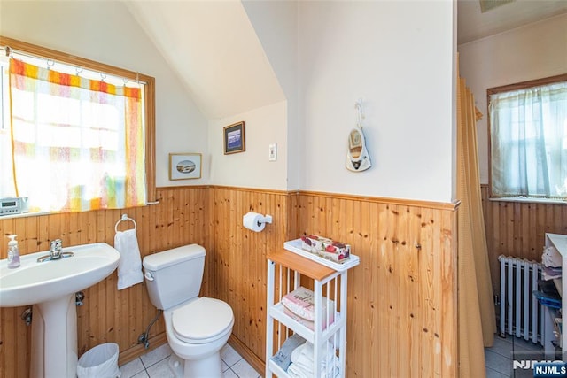 bathroom featuring radiator, sink, vaulted ceiling, tile patterned floors, and toilet