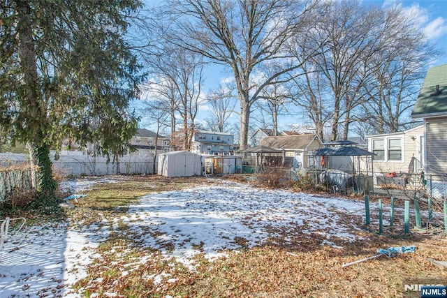 snowy yard with a shed