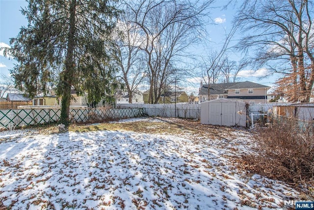 yard layered in snow with a storage unit