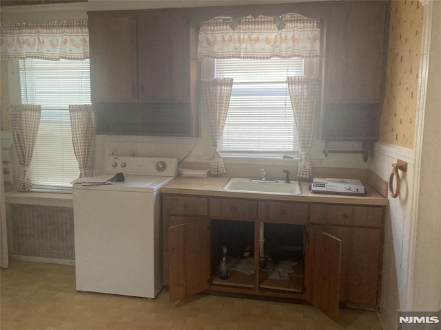 laundry room featuring cabinets, plenty of natural light, washer / dryer, and sink