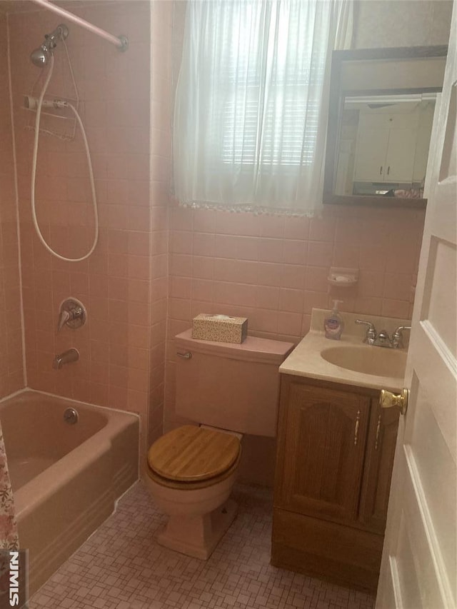 full bathroom featuring tile walls, vanity, tasteful backsplash, toilet, and tiled shower / bath