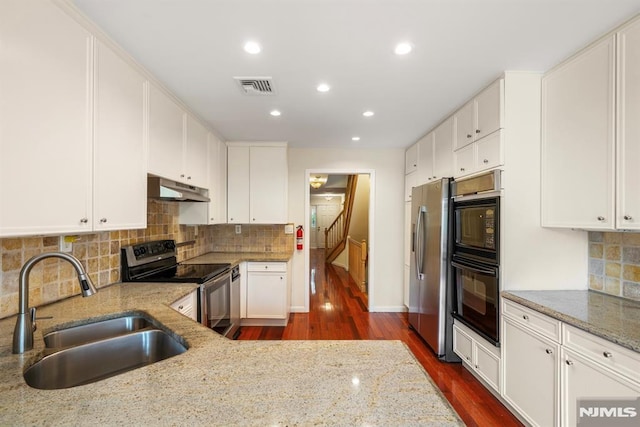 kitchen featuring white cabinetry, light stone countertops, stainless steel appliances, and sink