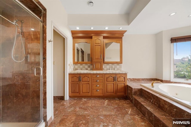 bathroom featuring tasteful backsplash, vanity, and plus walk in shower