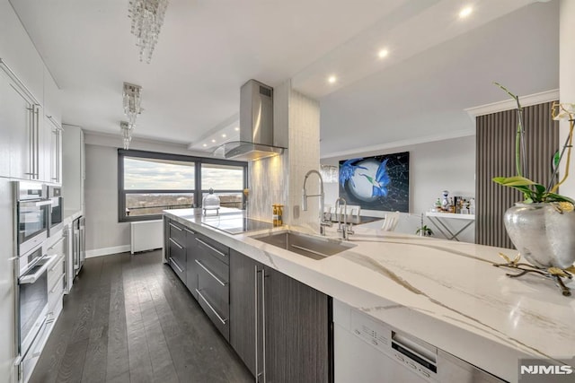 kitchen with island range hood, sink, stainless steel oven, white dishwasher, and light stone countertops