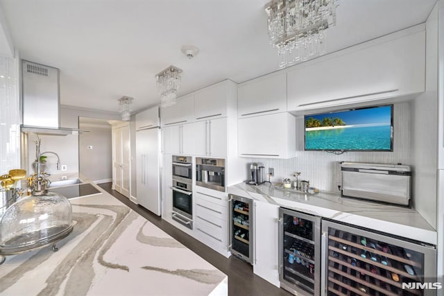 kitchen with wine cooler, light stone countertops, sink, and white cabinets