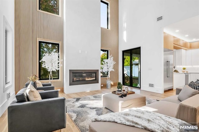 living room with light hardwood / wood-style flooring and a high ceiling