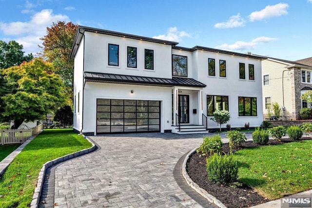 view of front of property with a garage and a front lawn