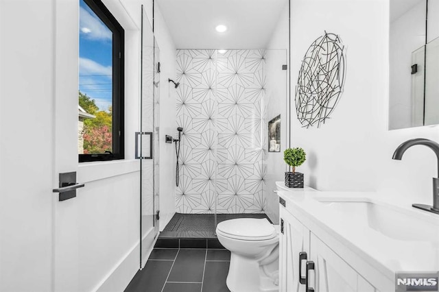 bathroom with an enclosed shower, vanity, tile patterned floors, and toilet