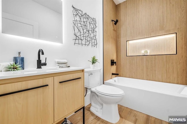 full bathroom featuring vanity, hardwood / wood-style floors, bathing tub / shower combination, and toilet