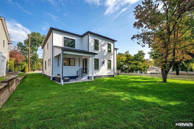 rear view of house featuring a lawn