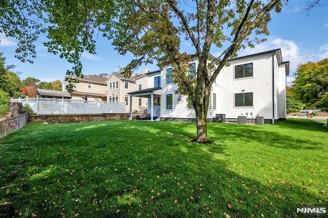 rear view of house with a yard and central AC