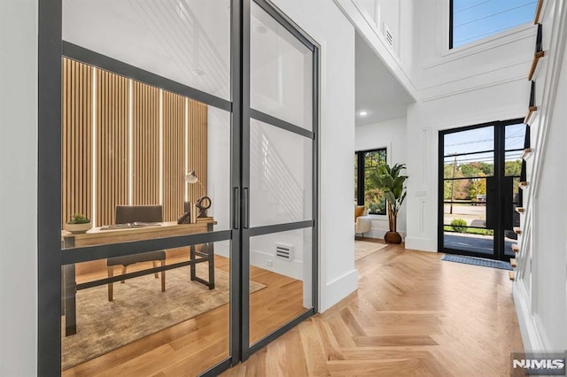 interior space featuring light parquet flooring and a high ceiling