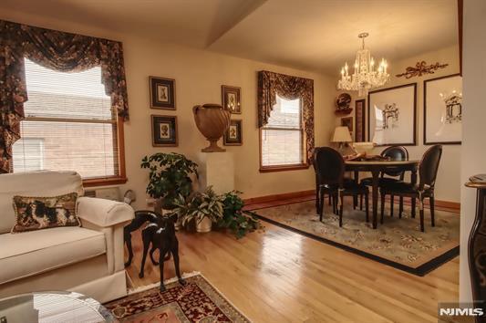 dining area with hardwood / wood-style flooring, lofted ceiling, and a chandelier