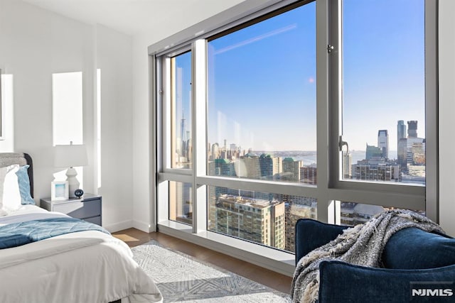 bedroom with multiple windows and hardwood / wood-style flooring