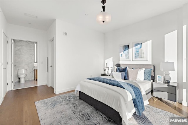 bedroom featuring wood-type flooring and ensuite bathroom