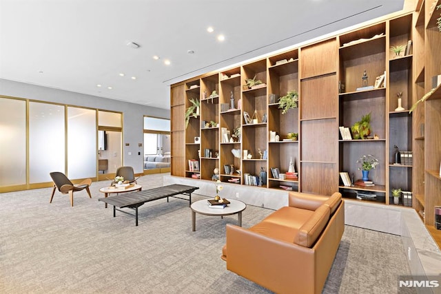 sitting room with light carpet and built in shelves