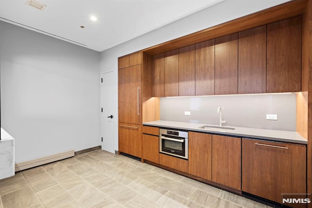 kitchen featuring sink, oven, and a baseboard heating unit