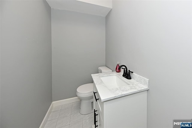 bathroom featuring vanity, tile patterned flooring, and toilet