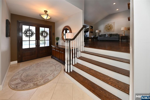 tiled entryway with lofted ceiling and french doors