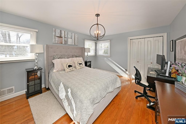 bedroom with a notable chandelier, hardwood / wood-style flooring, and a closet