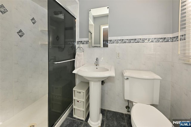 bathroom featuring sink, tiled shower, tile walls, and toilet