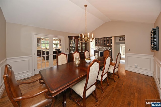 dining space featuring a notable chandelier, dark wood-type flooring, vaulted ceiling, and french doors