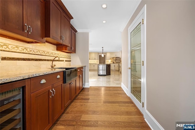 interior space featuring dishwasher, hanging light fixtures, tasteful backsplash, light stone countertops, and beverage cooler