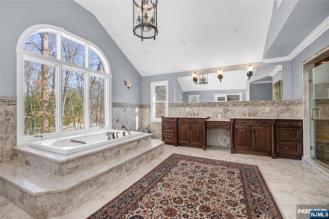 bathroom with vaulted ceiling, plenty of natural light, and a notable chandelier