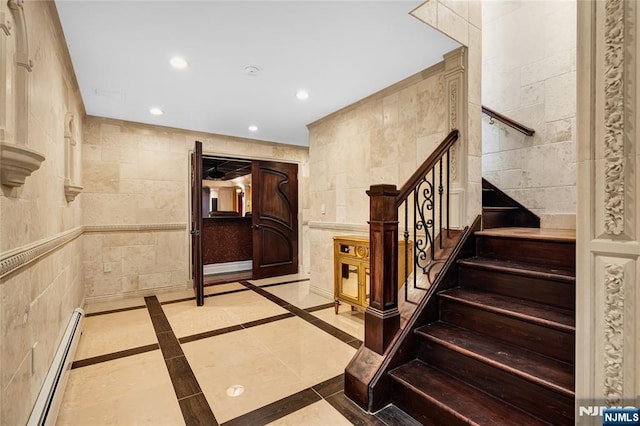 stairway featuring a baseboard heating unit