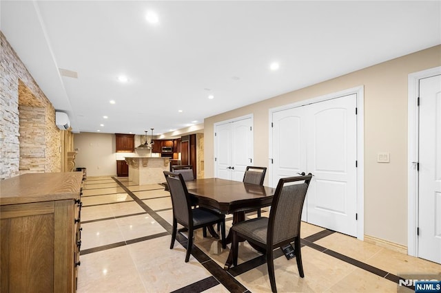 dining area with a wall mounted air conditioner and light tile patterned floors