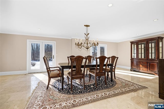 dining area with ornamental molding, french doors, and a chandelier