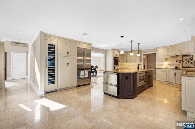 kitchen with pendant lighting, backsplash, built in appliances, cream cabinets, and light stone counters