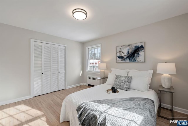 bedroom with radiator, wood-type flooring, and a closet