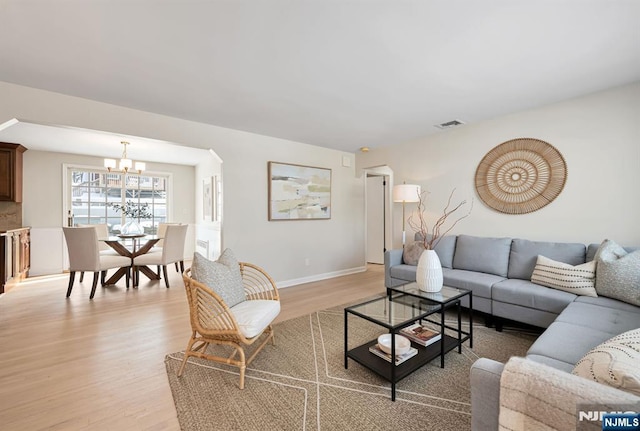 living room featuring a chandelier and light hardwood / wood-style floors