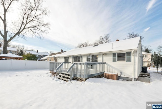 snow covered house with a wooden deck