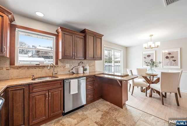 kitchen featuring sink, light stone counters, tasteful backsplash, dishwasher, and pendant lighting