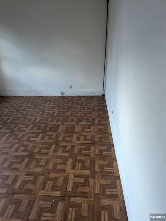 spare room featuring dark parquet flooring