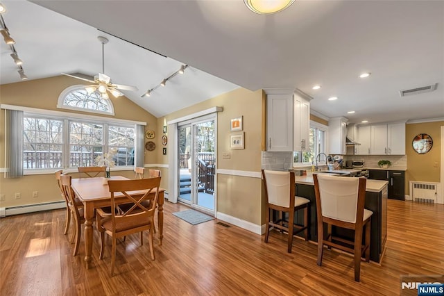 dining area featuring lofted ceiling, ceiling fan, a baseboard heating unit, radiator heating unit, and light hardwood / wood-style floors