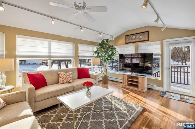 living room featuring a baseboard heating unit and plenty of natural light