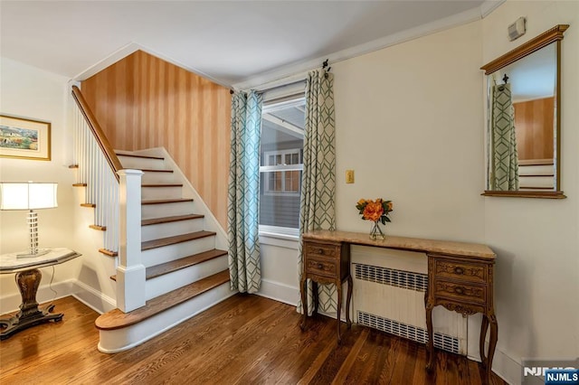 stairway featuring crown molding, radiator heating unit, and hardwood / wood-style floors