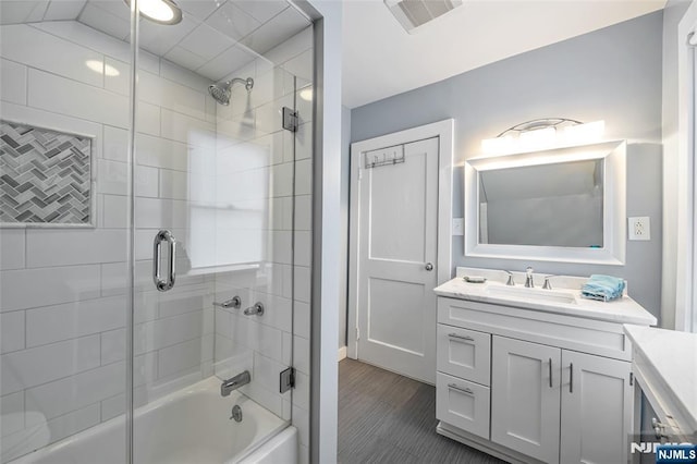 bathroom with vanity and bath / shower combo with glass door