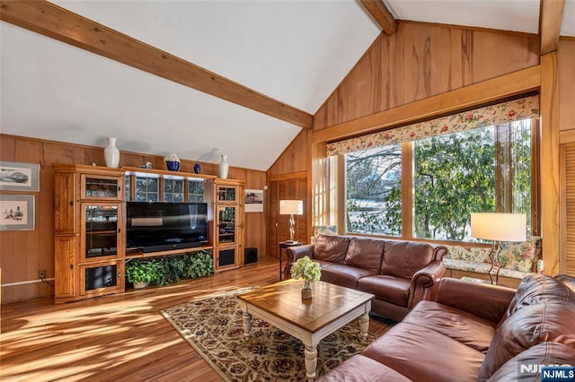 living room featuring lofted ceiling with beams, hardwood / wood-style floors, and wood walls