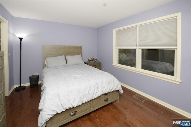 bedroom with dark wood-type flooring